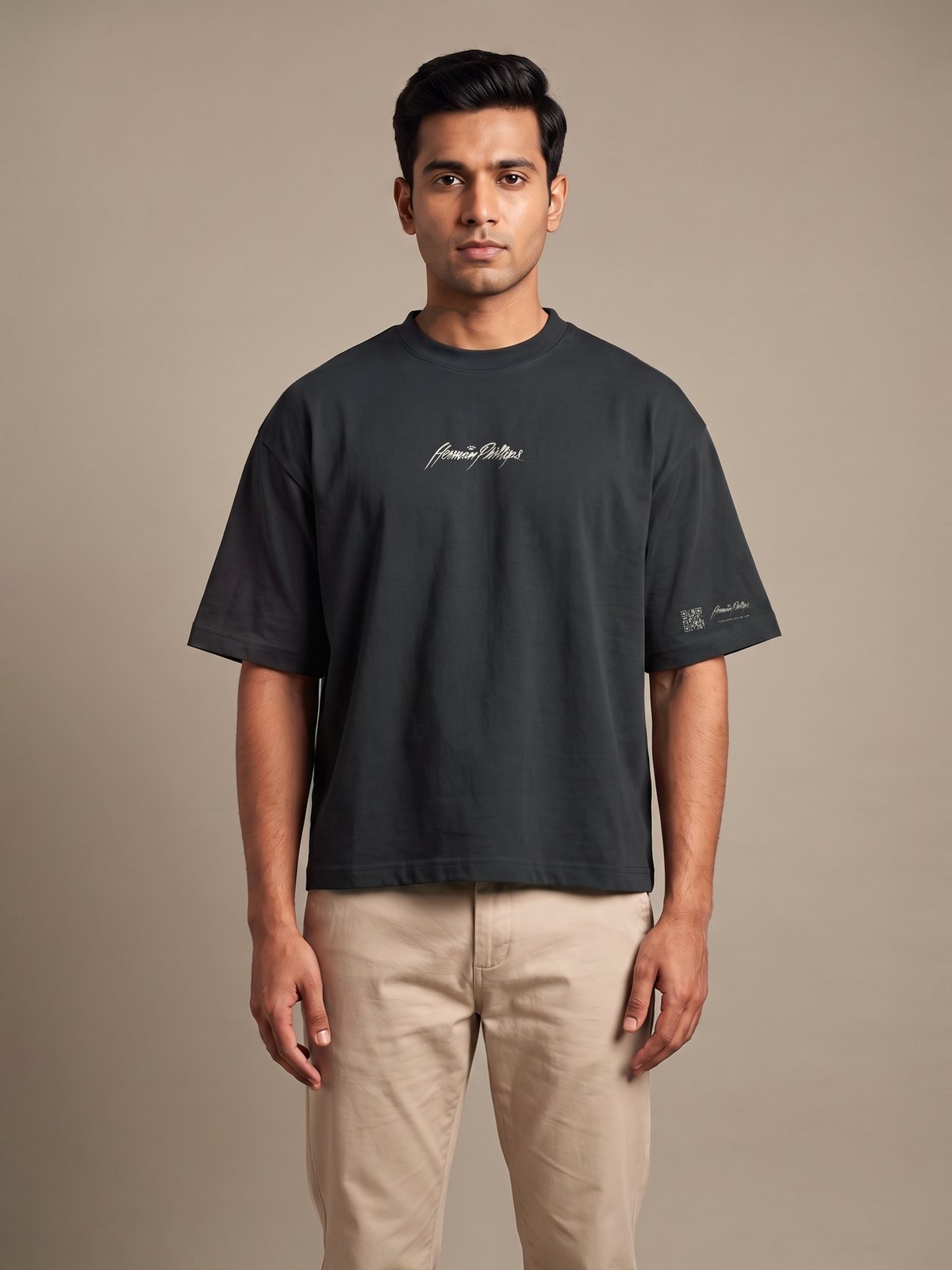 Model wearing the black boxy tee, Herman Phillips script on the chest