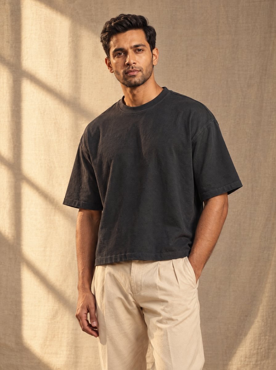 Model in warm natural light wearing the Herman Phillips blank black boxy tee
